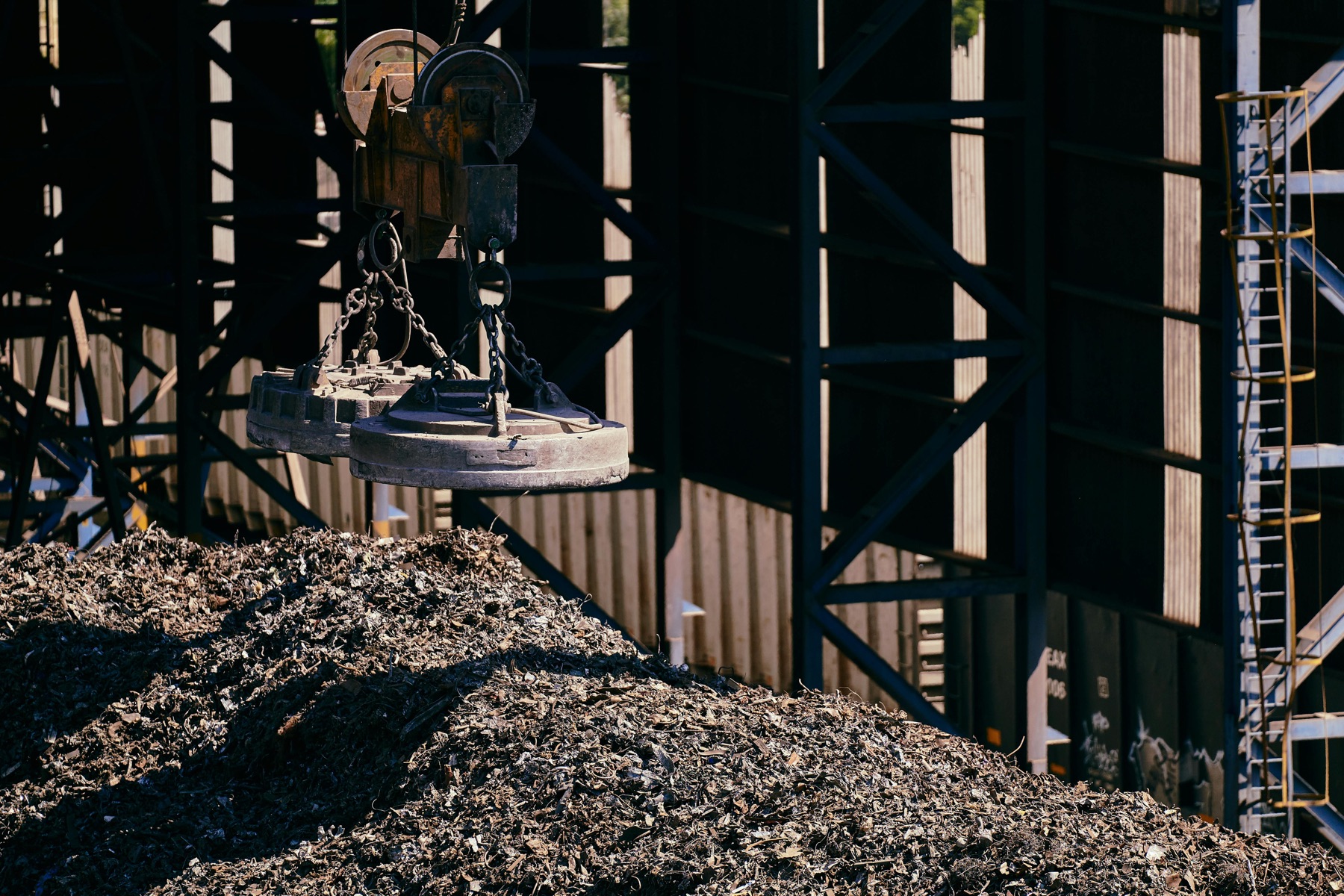 Crane magnet operating at an industrial metal recycling yard
