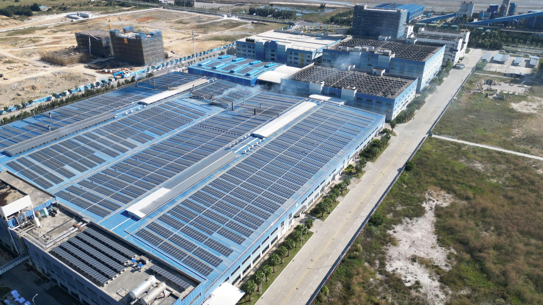 Aerial view of an industrial facility with rooftop solar panels